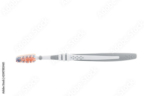 A white and gray plastic toothbrush with orange bristles and a rubber tongue cleaner, isolated on a white background. Close-up.