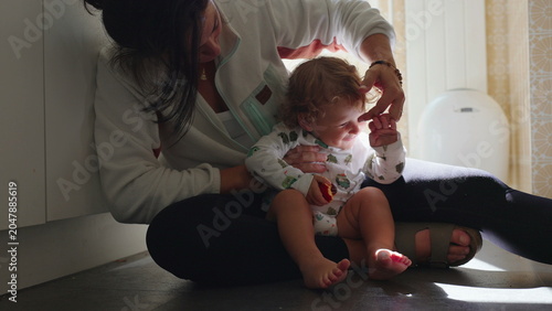 Canvastavla Mother caring for toddler during runny nose cleaning at home, authentic parentin