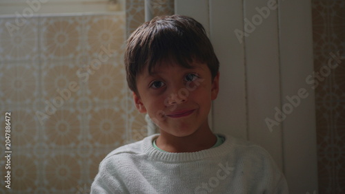 Fotografija Smiling boy portrait indoors at home, happy child looking at camera in warm natu