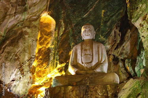 Tablou pe pânză Stone Buddha statue inside the sacred Huyen Khong Cave, Marble Mountains in Da N