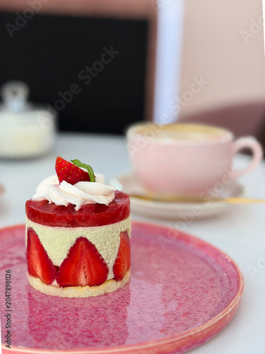 Elegant French Fraisier cake with fresh strawberries and whipped cream in a cafe. High quality photo