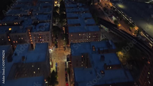 Nighttime aerial establishing shot over South Bronx revealing New York City, illuminated cityscape, buildings, streets and Manhattan skyline