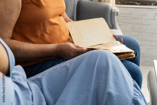 Senior woman holding vintage empty photo album pages