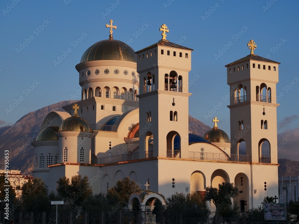 Obraz premium Orthodox Cathedral with Mountain Background at Sunset