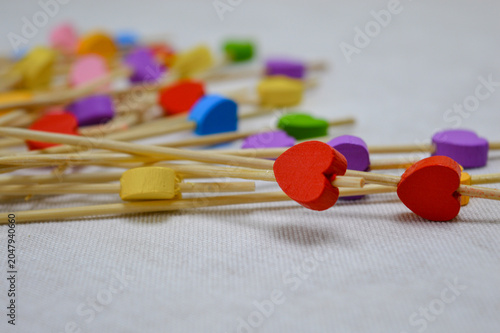 Schilderij op canvas A scattering of wooden party toothpicks topped with colorful, small wooden hearts