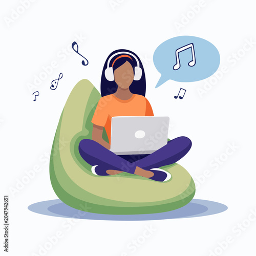 Woman with headphones using laptop and listening to music