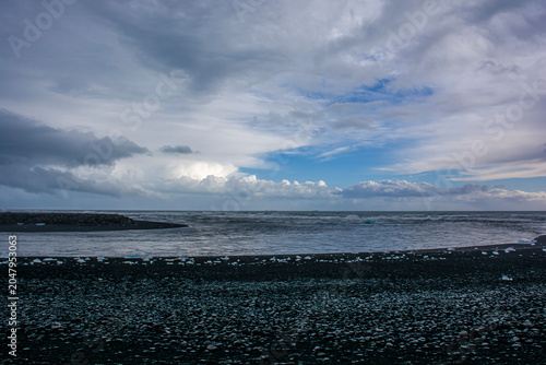 Scenic landscape of Jokulsarlon glacial beach with ice chunks on dark volcanic sand. High quality photo