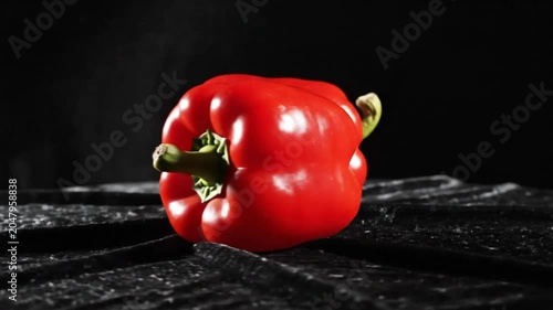 Red Bell Peppers Resting Side By Side on Black Textured Fabric Displaying Bright Glossy Texture