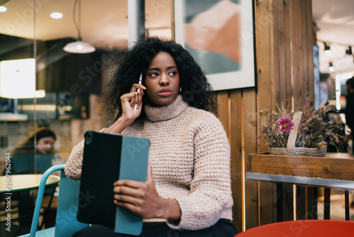 Financial freedom digital nomad tablet analysis task. Serious African American female freelancer looking away thinking over corporate business project data solution  authentic representation