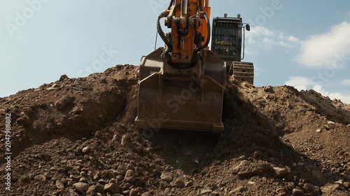 Excavator Bucket Moving Earth and Rocks at Construction Site
