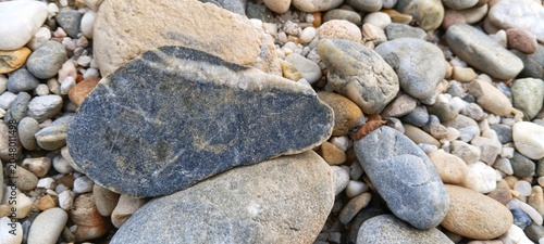 Obraz na płótnie Close-up of rugged unpolished river rocks alongside water-smoothed pebbles, symb