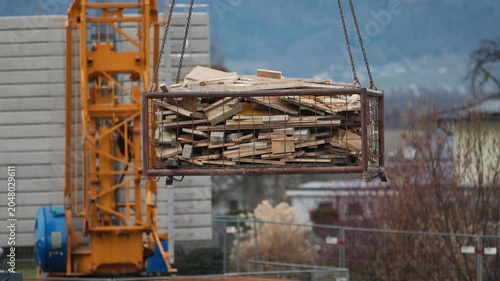 Crane Lifting Construction Wood Waste Container on Building Site