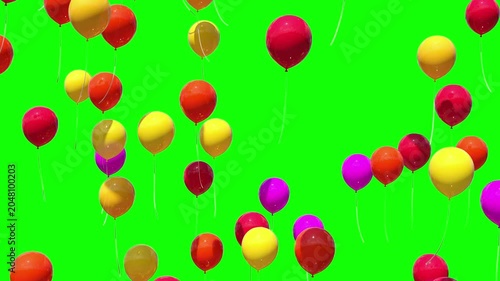 Multicolored balloons rise into the air against a green background.