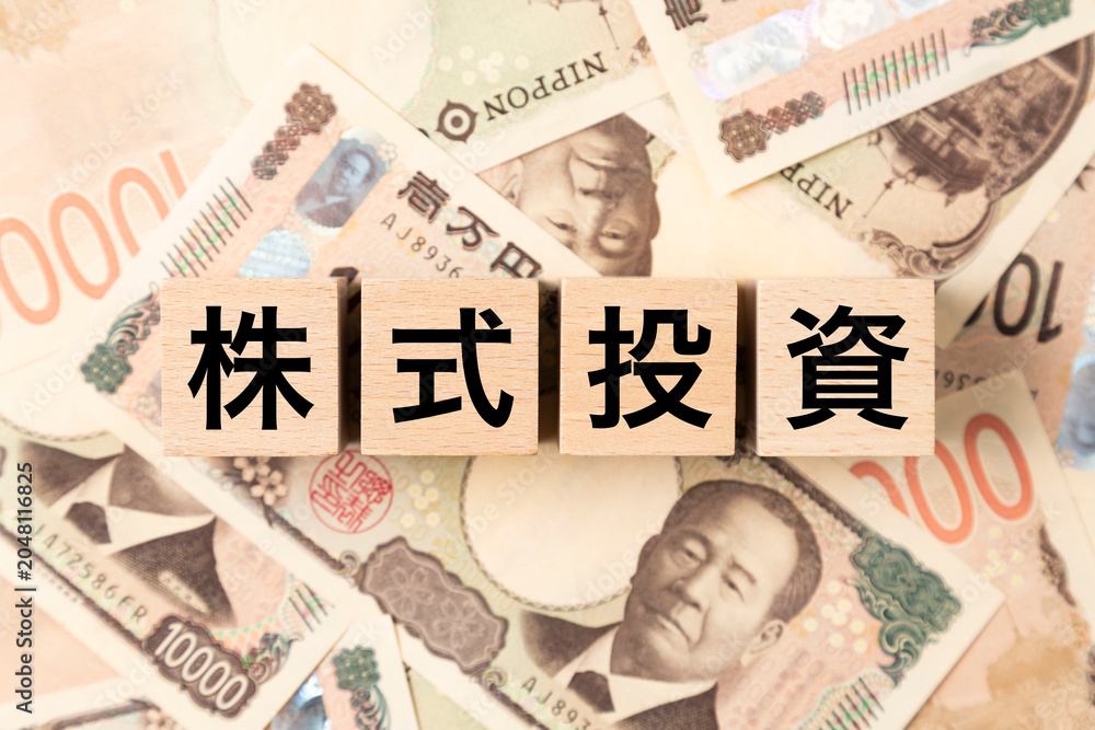 Fototapeta premium 「株式投資」と書かれたブロックとたくさんの一万円札
