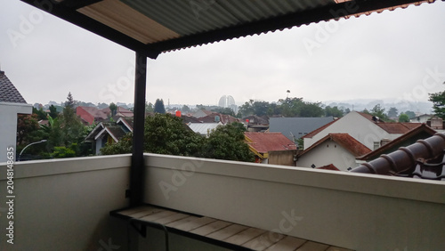 Konstfotografi Residential neighborhood view from a balcony overlooking houses, trees, and cloudy sky in a suburban urban area