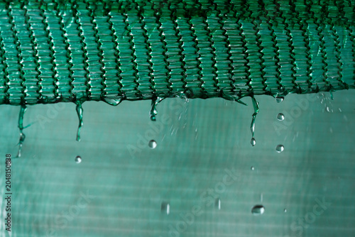 Raindrops trickling down from the canvas.