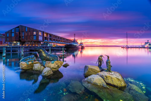 Canvastavla Waterfront sculptures at Hobart Harbour during sunrise, Tasmania, featuring colourful reflections, calm water and the city's vibrant maritime precinct