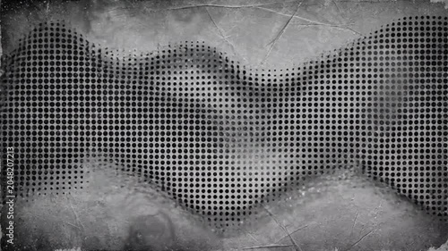 A close-up view of a metallic mesh surface with a wavy pattern on an industrial background with smoke