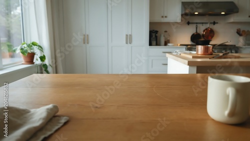 Steaming white coffee mug on wooden kitchen countertop with blurred background