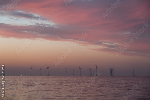 Offshore Wind Turbines on Ocean Horizon at Dawn from Geumneung Beach Jeju Island, South Korea