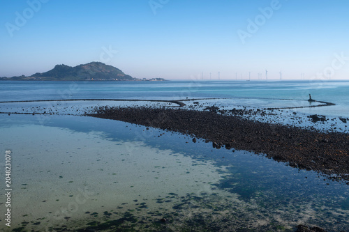 Foto Volcanic Rock Fish Trap with Offshore Wind Turbines at Geumneung Beach Sunset Se