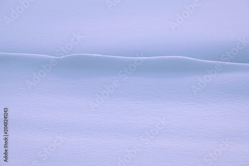 Valokuva 雪原の雪が風で盛り上がり小さい砂丘のようだった。朝日でブルーピンクのコントラストが奇麗だった。