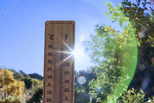 Outdoor thermometer displaying high mercury levels, depicting extreme summer heat, global warming, and hot weather conditions
