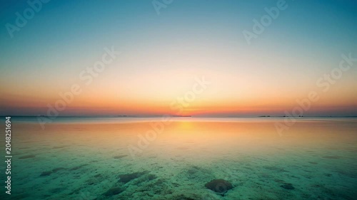 Sunset over calm sea water.