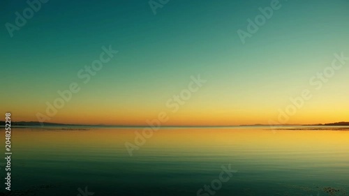 Sunset over calm water horizon.