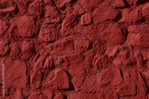 Rough red stone wall with uneven texture
