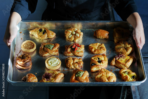 Pastries on a baking sheet with various artistic shapes are still fresh from the oven.