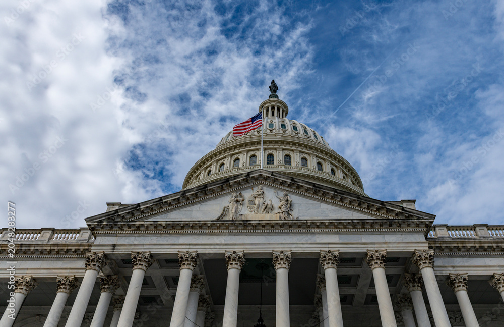 Naklejka premium Capitol famous architecture in Washington DC skyline. Patriotic exterior landmark in Washington DC cloudy sky. Washington law Congress Senate democracy Washington. Historic national icon.