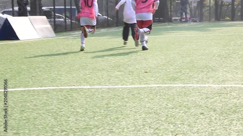 사람 축구 선수 스포츠 훈련 코트 야외 일상 소품 디테일 자재: 야외 인조잔디구장에서 유소년 축구 선수들이 공을 사이에 두고 화이트라인 근처에서 경합하는 하체 중심의 동영상 클립입니다.