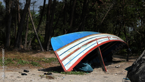 A damaged fishing boat kept for repairing on a beach in Kerala, India