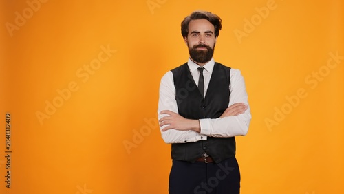 Принти на полотні Restaurant waiter strikes air of optimism in studio as he prepares to serve consumers at table