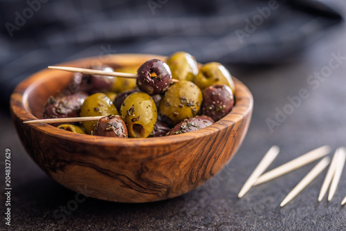 Marinated Mixed Olives in Wooden Bowl With Olive Oil and Toothpicks Mediterranean Appetizer