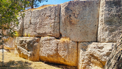 Ancient polygonal masonry wall at the Hill of the Nymphs, Athens, Greece, with megalithic stone blocks fitted without mortar, resembling the massive stone walls with distinct beveled edges in Baalbek
