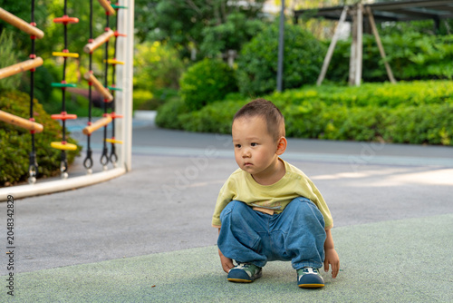 Toddler boy watching playground activity outdoors