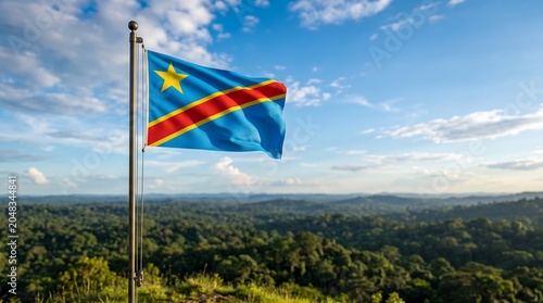 National flag of Democratic Republic of the Congo waving on metal pole over lush tropical forest landscape
