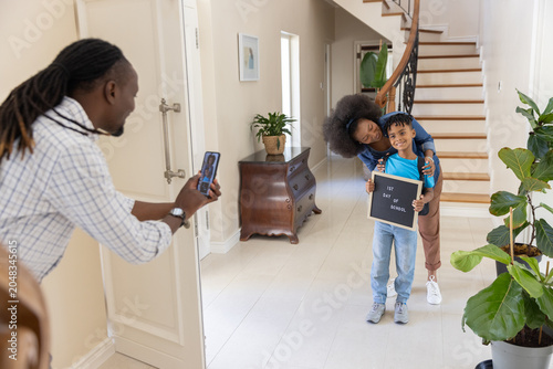 Letter board displaying '1st day of school' while smartphone is capturing scene in entry hallway