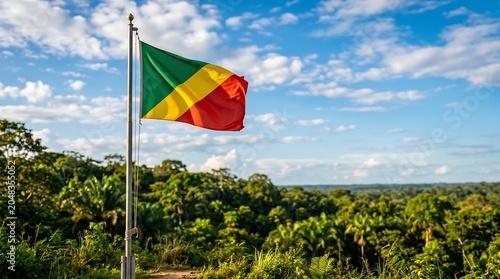Republic of the Congo flag waving on pole over lush tropical rainforest landscape with sky