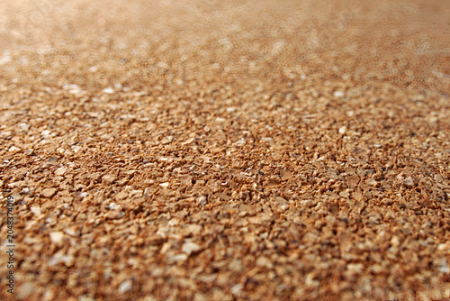 Close-up macro of coarse material with varying shades of brown, displaying irregular textured fragments under natural light