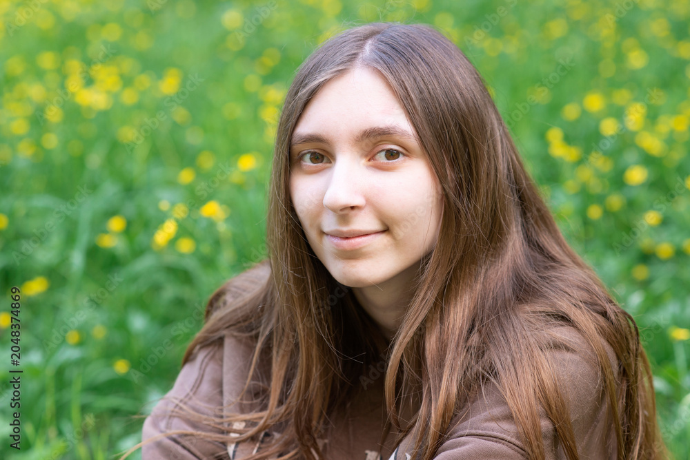 Fototapeta premium Young woman smiling at camera in summer park portrait