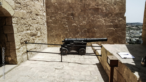 Old cast iron cannon stands on fortress wall of Citadella de Victoria Citadel in Rabat Victoria town on Gozo Island in Malta