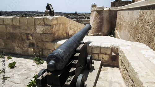 Old cast iron cannon stands on a fortress wall of Citadella de Victoria Citadel in Rabat Victoria town on Gozo Island in Malta