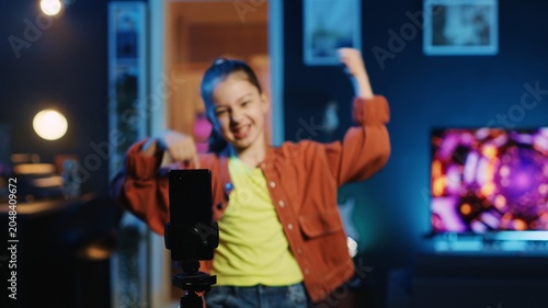 Foto Kid vlogger recording trendy dance video clip for social media using cellphone on tripod stabilizer, entertaining audiences