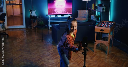 Foto Jib up shot of young media star recording trendy dance video clip for social media using cellphone on tripod stabilizer, entertaining audiences