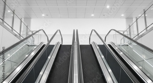 Modern escalator ascending in a clean, minimalist indoor architectural space, highlighting smooth movement and contemporary design.