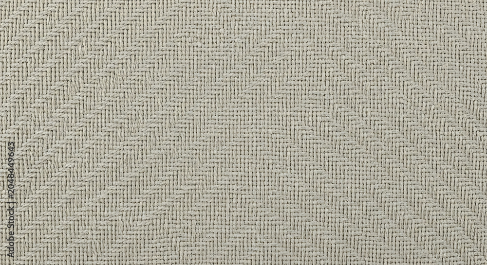 Fototapeta premium Woven textile with a herringbone pattern a close up view of the neutral toned fabric texture weave material