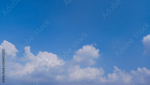A blue sky with cumulonimbus clouds in the distance 